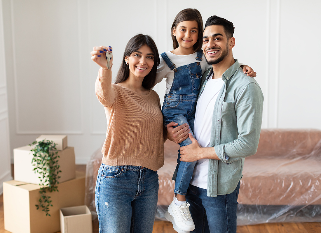 Personal Insurance - Happy Family Holding House Keys in Their New Home